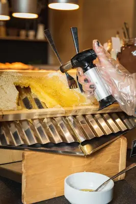a person is preparing food on a counter at Hotel Arte SPA & Park in Velingrad