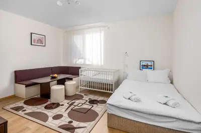 a bedroom with a bed and a crib and a table at Apartments Ivadoni in Velingrad