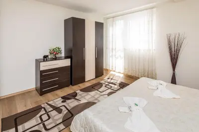 a bedroom with a white bed and a dresser at Apartments Ivadoni in Velingrad