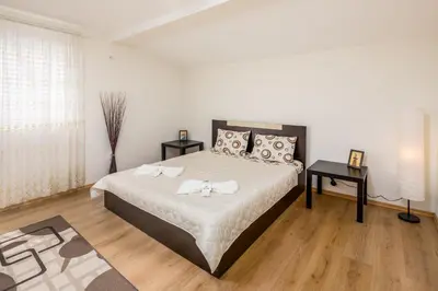 a bedroom with a large bed with white sheets and pillows at Apartments Ivadoni in Velingrad