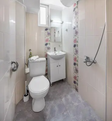 a bathroom with a white toilet and a sink at Apartments Ivadoni in Velingrad