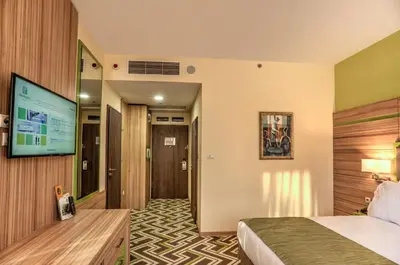a hotel room with a bed and a flat screen tv at Holiday Inn Plovdiv by IHG in Plovdiv