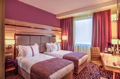 a hotel room with two beds and a desk at Holiday Inn Plovdiv by IHG in Plovdiv