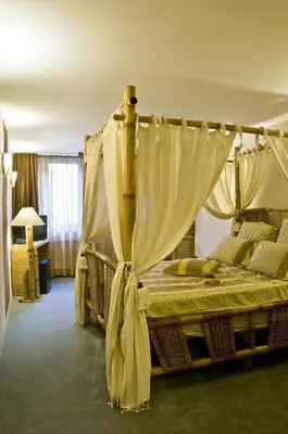 a bedroom with a canopy bed with curtains at Hotel 4 Zona in Sofia