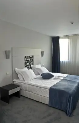 a bedroom with a large bed and a window at Hotel 4 Zona in Sofia