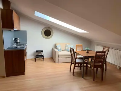 a living room with a table and chairs and a couch at Villa Park Studio Apartment nr 409 in Borovets