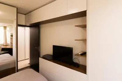 a bedroom with a bed and a tv on a wall at Lozenets Apartment in Sofia