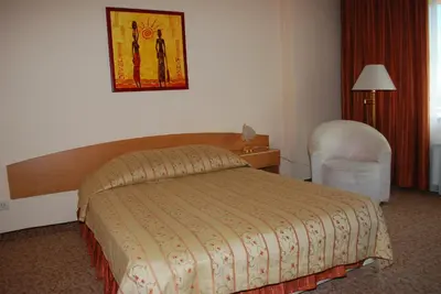 a hotel room with a bed and a chair at Hotel Velbazhd in Kyustendil