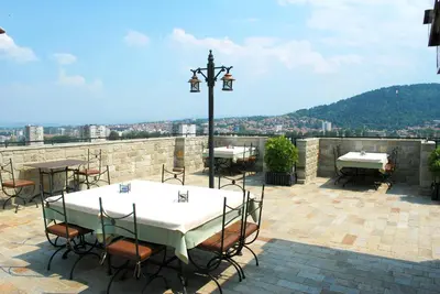 a table and chairs on a patio with a view at Hotel Velbazhd in Kyustendil