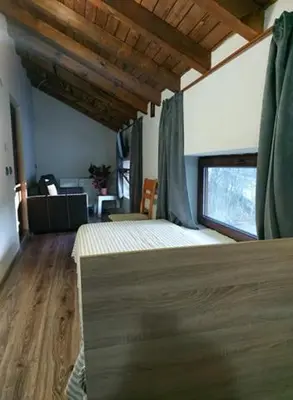 a bedroom with a bed in a room with a window at Danailovi Guest House in Sapareva Banya