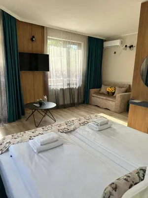 a bedroom with a large bed with two towels on it at Family Hotel Neliya in Velingrad