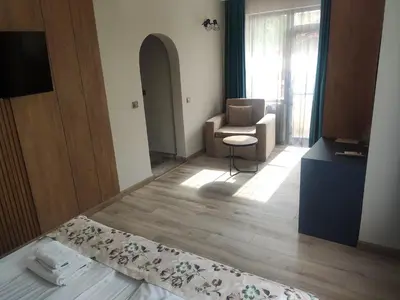 a room with a bed and a chair and a window at Family Hotel Neliya in Velingrad