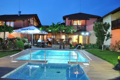 a swimming pool in front of a house at Family hotel Gradina in Ognyanovo
