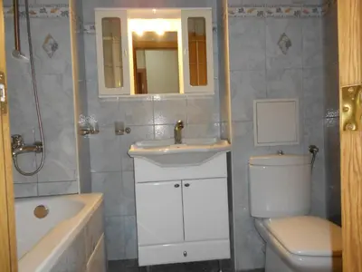a bathroom with a sink and a toilet and a tub at Апартамент Мур in Sofia