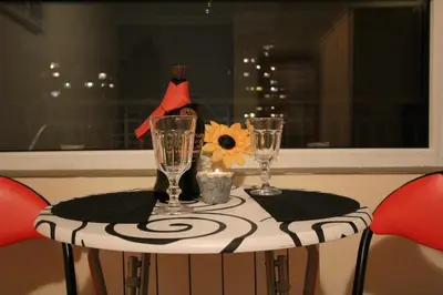 a table with two wine glasses and a flower on it at Apartment 132 in Sofia