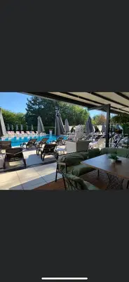 a group of tables and chairs with umbrellas and a pool at Hotel Ostrova in Plovdiv