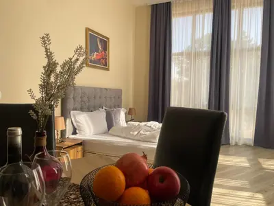 a living room with a table with fruit and a bed at Hotel Ostrova in Plovdiv