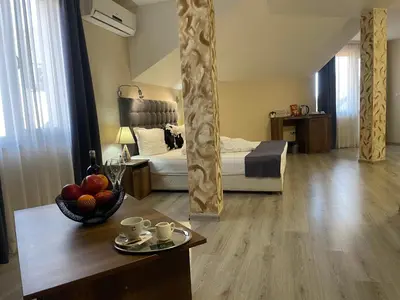 a room with a bed and a table with a bowl of fruit at Hotel Ostrova in Plovdiv