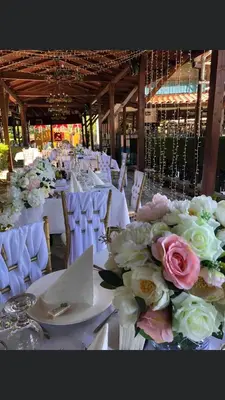 a group of tables with white chairs and flowers at Hotel Ostrova in Plovdiv