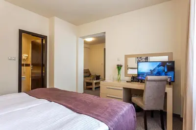 a hotel room with a bed and a desk with a computer at Sofia Palace Hotel by HMG in Sofia