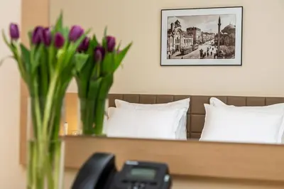 two vases with purple tulips sitting on a bed at Sofia Palace Hotel by HMG in Sofia