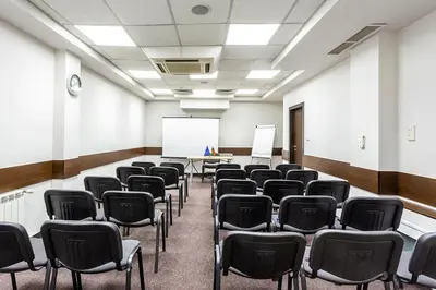 an empty room with chairs and a whiteboard at Sofia Palace Hotel by HMG in Sofia