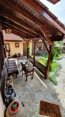 a patio with a wooden pergola and a table and chairs at Guest rooms Colorit in Koprivshtitsa