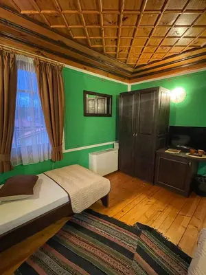 a room with a bed and a green wall at Guest rooms Colorit in Koprivshtitsa