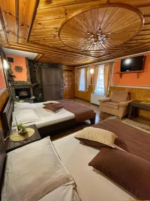 a large room with two beds and a ceiling at Guest rooms Colorit in Koprivshtitsa