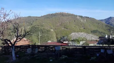 a mountain in the background of a village with a fence at Semana Guesthouse in Vrata