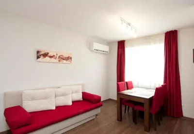 a living room with a red couch and a table at Sofia Top Apartments in Sofia