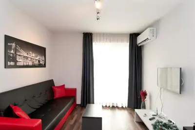 a living room with a black couch and red furniture at Sofia Top Apartments in Sofia