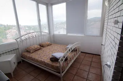 a bedroom with a bed in a room with windows at Snow Heaven Hotel in Bankya