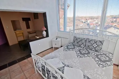 a bedroom with a white bed and a window at Snow Heaven Hotel in Bankya