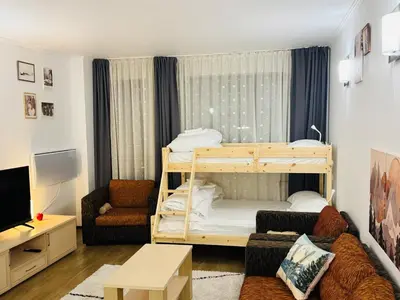 a living room with a bunk bed and a couch at Stenata Huge Ski To Door Apartments in Pamporovo
