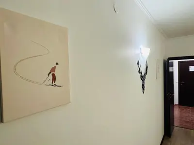 a painting of a man on skis on a wall at Stenata Huge Ski To Door Apartments in Pamporovo