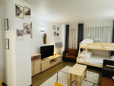 a bedroom with a bunk bed and a living room at Stenata Huge Ski To Door Apartments in Pamporovo