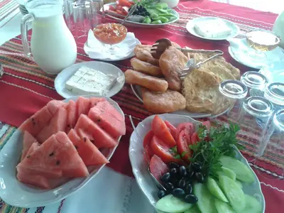 a table with plates of food on a table at Popsokol House in Bratsigovo