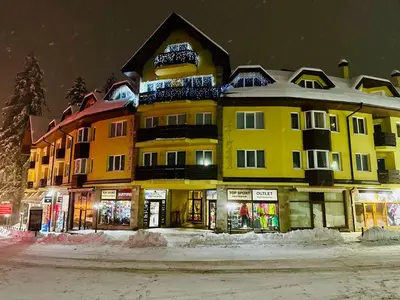 a large yellow building on the side of a street at GM Royal Plaza in Borovets