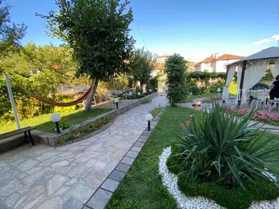 a garden with a walkway with flowers and plants at Guest House Detelina in Devin