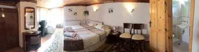a bedroom with a large bed and a bathroom at Guest House Detelina in Devin