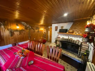 a dining room with a table and a fireplace at Guest House Detelina in Devin