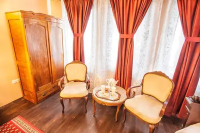 a living room with two chairs and a table at Hotel Evmolpia in Plovdiv