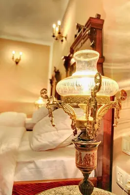 a lamp on a table in front of a bed at Hotel Evmolpia in Plovdiv