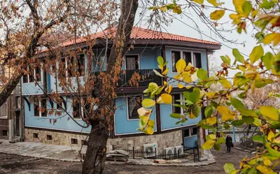 a blue house with a tree in front of it at Hotel Evmolpia in Plovdiv