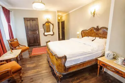 a bedroom with a large bed with a wooden frame at Hotel Evmolpia in Plovdiv
