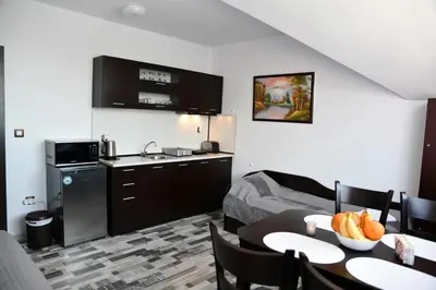 a hotel room with a kitchen and a table with fruit on it at Ski Apartment Boyika Iglika 2 in Borovets