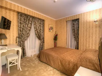 a hotel room with a bed and a desk at Family Hotel Agoncev in Sofia