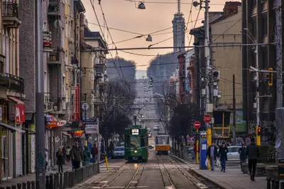 a green trolly tram driving down a city street at Family Hotel Agoncev in Sofia