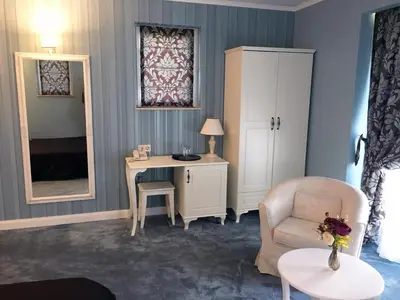 a room with a desk and a chair and a mirror at Family Hotel Agoncev in Sofia
